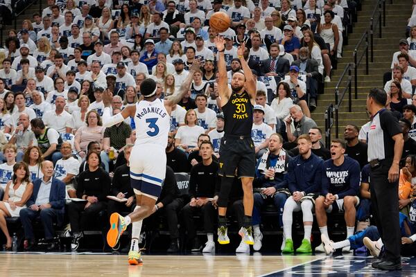 Golden State Warriors guard Stephen Curry (30) shoots over Minnesota Timberwolves forward Jaden McDaniels (3) during the first half of Game 1 of an NBA basketball second-round playoff series, Tuesday, May 6, 2025, in Minneapolis. (AP Photo/Abbie Parr)