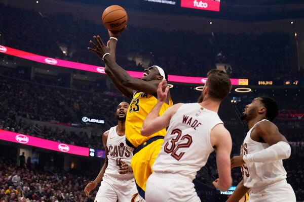 Indiana Pacers forward Pascal Siakam (43) goes to the basket between Cleveland Cavaliers forward Evan Mobley, left, forward Dean Wade (32) and guard Donovan Mitchell, right, in the first half during Game 1 in the Eastern Conference semifinals of the NBA basketball playoffs Sunday, May 4, 2025, in Cleveland. (AP Photo/Sue Ogrocki)