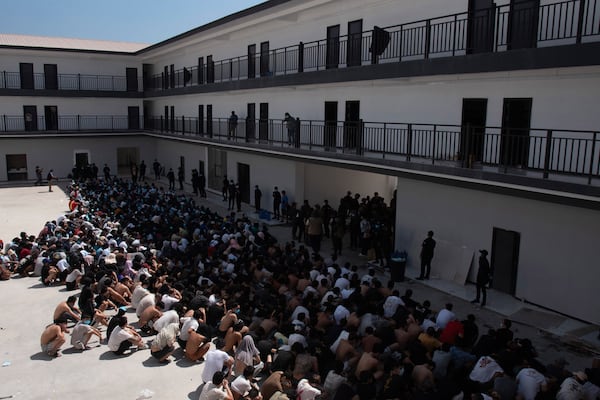 People from China, Vietnam and Ethiopia, believed to have been trafficked and forced to work in scam centers, sit with their faces masked while in detention after being released from the centers in Myawaddy district in eastern Myanmar, Wednesday, Feb. 26, 2025. (AP Photo/Thanaphon Wuttison)