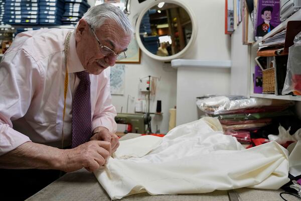 Italian tailor Raniero Mancinelli. who on his own initiative is making outfits for a possible future Pope, works on a pontiff's robe inside his shop in Rome, Wednesday, April 30, 2025. (AP Photo/Gregorio Borgia)
