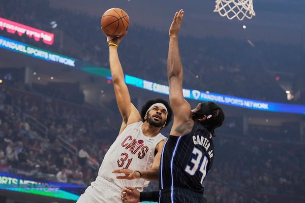 Cleveland Cavaliers center Jarrett Allen (31) shoots as Orlando Magic center Wendell Carter Jr. (34) defends in the first half of an NBA basketball game Sunday, March 16, 2025, in Cleveland. (AP Photo/Sue Ogrocki)