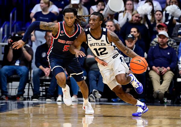 Butler guard Kolby King (12) dribbles the ball down court against St. John's guard Deivon Smith (5) during the first half of an NCAA college basketball game, Wednesday, Feb. 26, 2025, in Indianapolis, Ind. (AP Photo/Marc Lebryk)