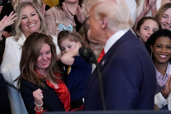 President Donald Trump turns to look at people behind him as he peaks before signing an executive order barring transgender female athletes from competing in women's or girls' sporting events, in the East Room of the White House, Wednesday, Feb. 5, 2025, in Washington. (AP Photo/Alex Brandon)