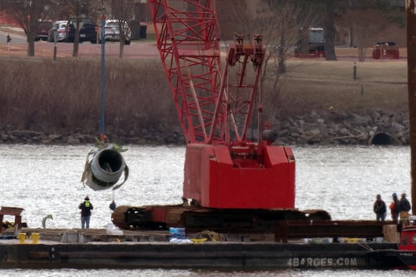 Rescue and salvage crews pull up a plane engine as cranes work near the wreckage of an American Airlines jet in the Potomac river from Ronald Reagan Washington National Airport, Monday, Feb. 3, 2025, in Arlington, Va. (AP Photo/Jose Luis Magana)