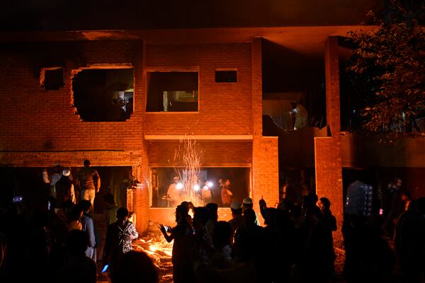 People watch as protesters use heavy machinery to demolish the residence of Sheikh Mujibur Rahman, Bangladesh's former leader and the father of the country's ousted Prime Minister Sheikh Hasina, at Dhanmondi, in Dhaka, Bangladesh, early Thursday, Feb. 6, 2025. (AP Photo/Mahmud Hossain Opu)