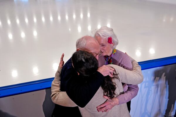 Former Olympic skater Nancy Kerrigan, center, embraces fellow former Olympic skater Tenley Albright, right, and former National Champion skater Paul George at The Skating Club of Boston, where six members of the club's community, including athletes, coaches and family, were killed in an airplane collision with a helicopter on Wednesday in Washington, Thursday, Jan. 30, 2025, in Norwood, Mass. (AP Photo/Charles Krupa)