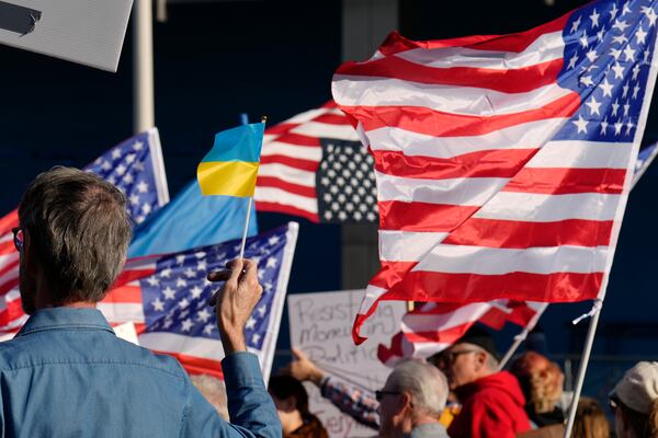 Flags fly in the wind during a protest against the Trump administration Tuesday, March 4, 2025, in Cleveland. (AP Photo/Sue Ogrocki)