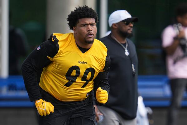 Pittsburgh Steelers head coach Mike Tomlin, right, watches as first round draft pick Derrick Harmon (99) warms up during the NFL football team's rookie camp in Pittsburgh, Friday, May 9, 2025. (AP Photo/Gene J. Puskar)