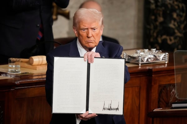 President Donald Trump holds up a signed executive order as he addresses a joint session of Congress at the Capitol in Washington, Tuesday, March 4, 2025. (AP Photo/Alex Brandon)