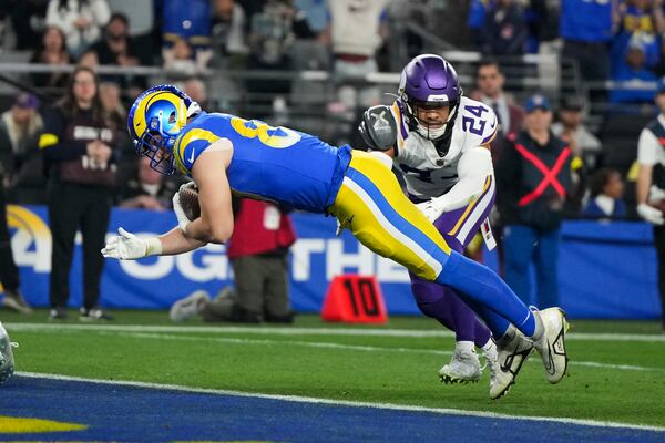 Los Angeles Rams tight end Davis Allen (87) scores on a 13-yard touchdown reception as Minnesota Vikings safety Camryn Bynum (24) defends during the first half of an NFL wild card playoff football game, Monday, Jan. 13, 2025, in Glendale, Ariz. (AP Photo/Rick Scuteri)