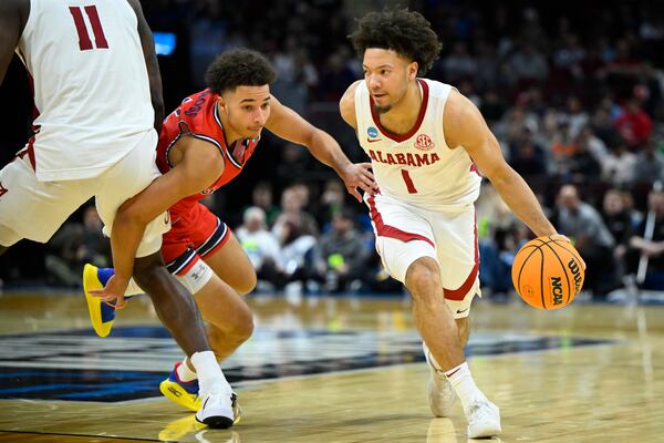 Alabama guard Mark Sears (1) dribbles beside Saint Mary's guard Jordan Ross, second from right, in the second half in the second round of the NCAA college basketball tournament, Sunday, March 23, 2025, in Cleveland. (AP Photo/David Richard)