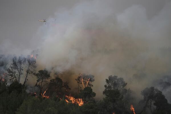 A plane uses a fire retardant to extinguish a fire burning in a forest near Jerusalem, Wednesday, April 30, 2025. (AP Photo/Mahmoud Illean)