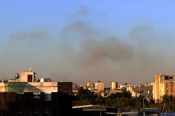 Smoke rises from the area around the International Airport following an airstrike, as seen from Sanaa, Yemen, Thursday, Dec. 26, 2024. The Israeli military reported targeting infrastructure used by the Houthis at the Sanaa International Airport, as well as ports in Hodeida, Al-Salif, and Ras Qantib, along with power stations.(AP Photo/Osamah Abdulrahman)