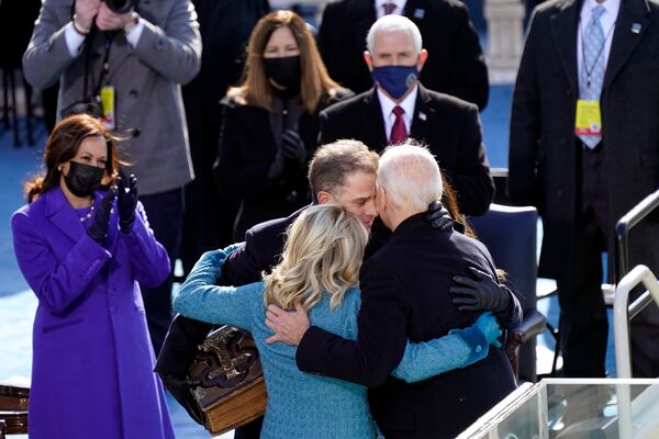 FILE - Outgoing Vice President Mike Pence looks on as incoming President Joe Biden embraces first lady Jill Biden, his son Hunter Biden and daughter Ashley Biden after he was sworn-in as the 46th president of the United Staes, at the U.S. Capitol in Washington, Jan. 20, 2021. Incoming Vice President Kamala Harris applauds at left. (AP Photo/Carolyn Kaster, File)