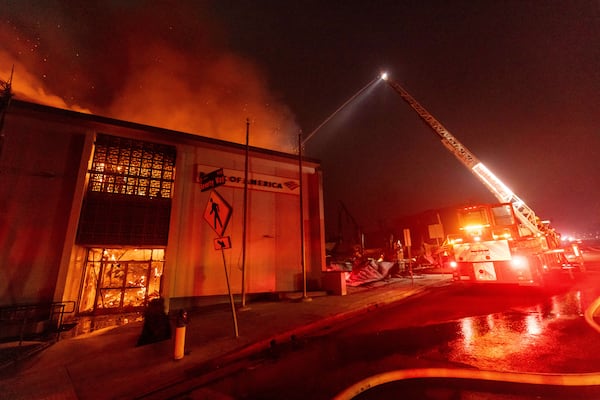 The Eaton Fire burns a Bank Of America branch Wednesday, Jan. 8, 2025 in Altadena, Calif. (AP Photo/Ethan Swope)