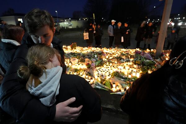 People take part in a vigil near the scene of a shooting at an adult education center on the outskirts of Orebro, Sweden, Thursday, Feb. 6, 2025. (AP Photo/Sergei Grits)