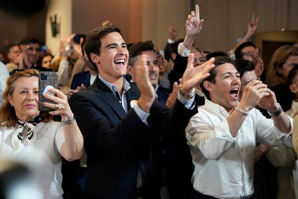 Supporters of the center-right ruling coalition of Prime Minister Luis Montenegro react to exit polls following Portugal's general election, in Lisbon, Sunday, May 18, 2025. (AP Photo/Armando Franca)