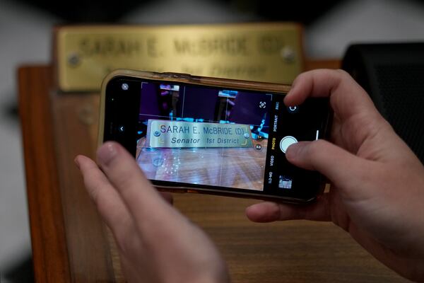 U.S.-Rep.-elect Sarah McBride, D-Del., photographs her desk nameplate on the Senate floor on her last day as a Delaware state senator at the Delaware Legislative Hall in Dover, Del., Monday, Dec. 16, 2024. (AP Photo/Carolyn Kaster)