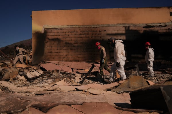 Search and rescue workers dig through the rubble left behind by the Eaton Fire, in Altadena, Calif., Tuesday, Jan. 14, 2025. (AP Photo/Jae C. Hong)