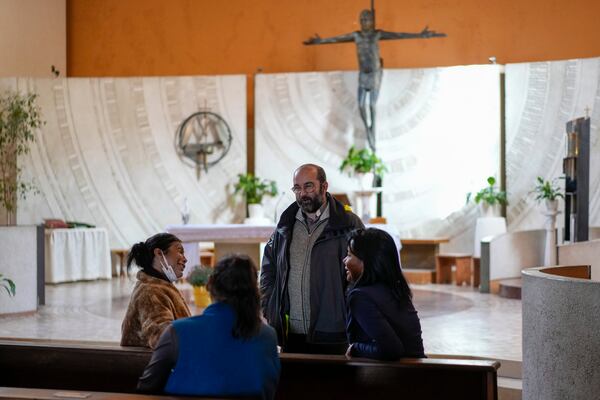 FILE - Priest Andrea Conocchia, third from left, speaks with transgender women, from left, Andrea Paola Torres Lopez from Colombia, also known as Consuelo, Claudia Vittoria Salas from Argentina and Carla Segovia from Argentina as they sit in the Beata Vergine Immacolata parish church in Torvaianica, Italy, Thursday, Nov. 16, 2023. (AP Photo/Andrew Medichini, File)