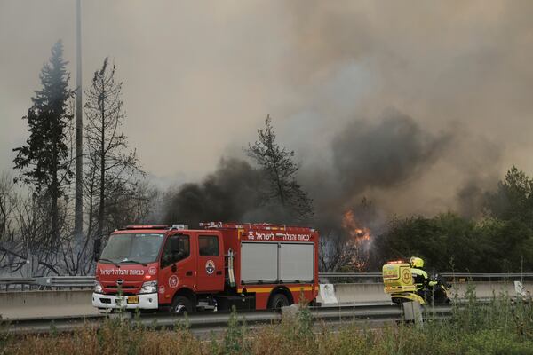 Firefighters work to extinguish a forest fire burning on a freeway to Jerusalem, Wednesday, April 30, 2025. (AP Photo/Mahmoud Illean)