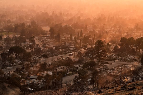 Smoke lingers over a neighborhood devastated by the Eaton Fire, Thursday, Jan. 9, 2025, in Altadena, Calif. (AP Photo/John Locher)