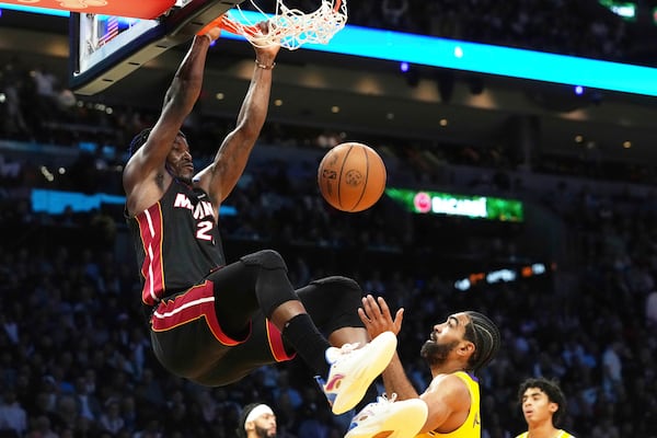 Miami Heat forward Jimmy Butler (22) dunks the ball over Los Angeles Lakers guard Gabe Vincent (7) during the second half of an NBA basketball game, Wednesday, Dec. 4, 2024, in Miami. (AP Photo/Marta Lavandier)