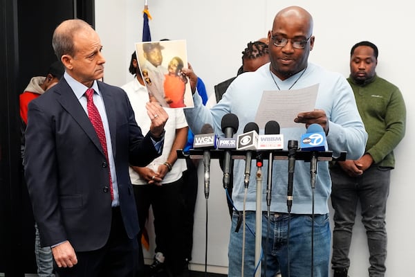 One of sexual assault survivor Marcus Walker, right, talks to media as Jerome Block, partner, Levy & Konigsberg LLP holds a photo together and he looks on during a news conference in Chicago, Tuesday, Feb. 11, 2025. (AP Photo/Nam Y. Huh)