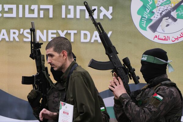 Israeli captive Or Levy, who has been held hostage by Hamas in Gaza since October 7, 2023, is escorted by Hamas fighters before being handed over to the Red Cross in Deir al-Balah, central Gaza Strip, Saturday Feb. 8, 2025. (AP Photo/Abdel Kareem Hana)