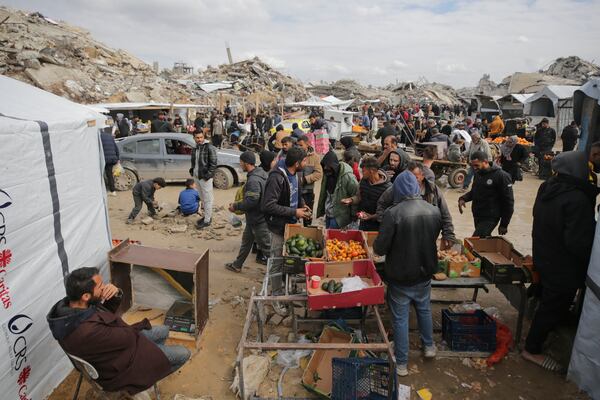 Palestinians purchase goods at a makeshift market set up amid widespread destruction caused by the Israeli military's ground and air offensive in Gaza City's Jabaliya refugee camp, Friday, Feb. 7, 2025. (AP Photo/Jehad Alshrafi)