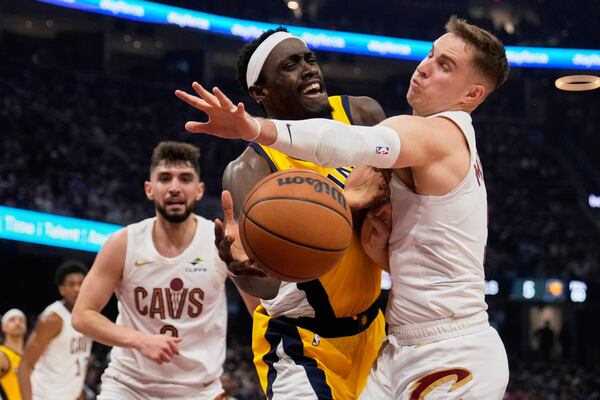 Indiana Pacers forward Pascal Siakam, center, is fouled by Cleveland Cavaliers guard Sam Merrill, right, in the first half during Game 1 in the Eastern Conference semifinals of the NBA basketball playoffs Sunday, May 4, 2025, in Cleveland. (AP Photo/Sue Ogrocki)