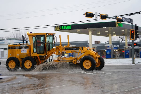 Slush is plowed on a street during a winter storm, Thursday, Jan. 9, 2025, in Arlington, Texas. (AP Photo/Julio Cortez)