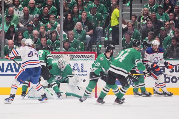 Edmonton Oilers left wing Evander Kane (91) scores against Dallas Stars goaltender Casey DeSmith (1) during the third period of Game 5 of the Western Conference finals in the NHL hockey Stanley Cup playoffs, Thursday, May 29, 2025, in Dallas. (AP Photo/Julio Cortez)