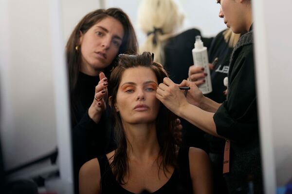 Model Isabeli Fontana gets made up by a make up artist in the backstage prior to the Marni Fall/Winter 2025-2026 Womenswear fashion show, during the Fashion Week, in Milan, Italy, Wednesday, Feb. 26, 2025. (AP Photo/Luca Bruno)