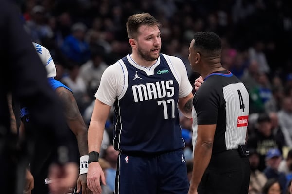 Dallas Mavericks guard Luka Doncic (77) questions a call by referee Sean Wright (4) during the first half of an NBA basketball game against the Portland Trail Blazers, Monday, Dec. 23, 2024, in Dallas. (AP Photo/LM Otero)