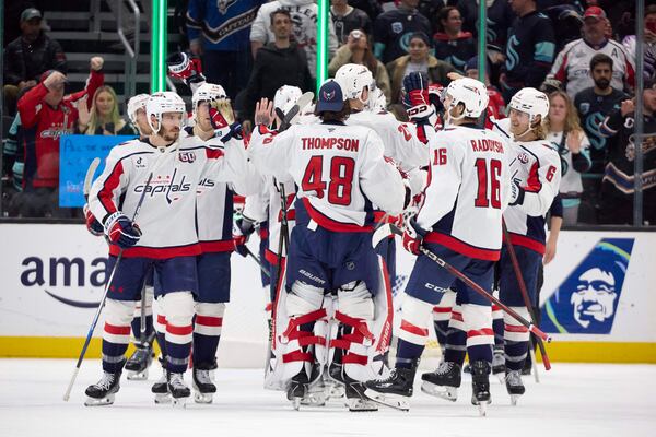 Washington Capitals players celebrate a win over the Seattle Kraken in an NHL hockey game, Thursday, Jan. 23, 2025, in Seattle. (AP Photo/John Froschauer)