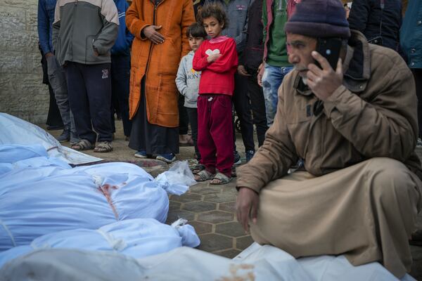 Children watch as the bodies of victims from overnight Israeli army strikes at multiple locations in the central Gaza Strip are laid together for funeral prayers, at Al-Aqsa Martyrs Hospital in Deir al-Balah, Friday, Jan. 3, 2025. According to Al-Aqsa Martyrs Hospital, 30 people, including 10 women and 7 children, were killed in several attacks overnight in central Gaza. (AP Photo/Abdel Kareem Hana)