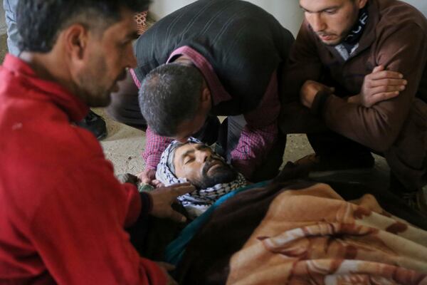 Residents mourn the body of Ayman Salem al-Suleiman, who was reportedly killed in an Israeli drone attack that claimed at least four lives, in Koayiah, southwestern Syria, Tuesday, March 25, 2025. (AP Photo/Malek Khattab)