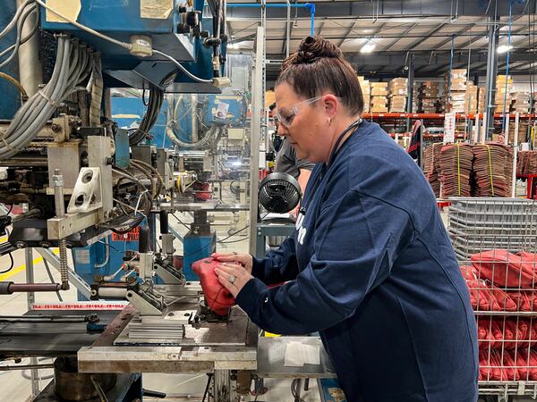 Nicole Snyder operates the machine inside the Wilson Sporting Goods football factory that prints "Philadelphia Eagles" and "Kansas City Chiefs" onto the official Super Bowl game balls Monday, January 27, 2025, in Ada, Ohio. (AP Photo/Patrick Aftoora-Orsagos)