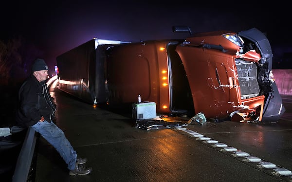 Mark Nelson, of Wis., waits with his tractor-trailer after it overturned during high winds and a possible tornado on Interstate 44 westbound at Villa Ridge, Mo., Friday, March 14, 2025. (Robert Cohen/St. Louis Post-Dispatch via AP)