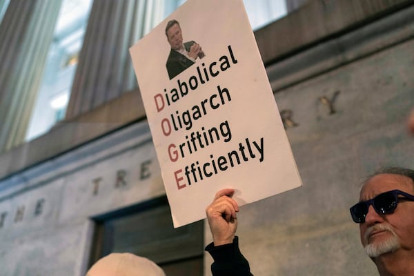 People protest during a rally against Elon Musk outside the Treasury Department in Washington, Tuesday, Feb. 4, 2025. (AP Photo/Jose Luis Magana)