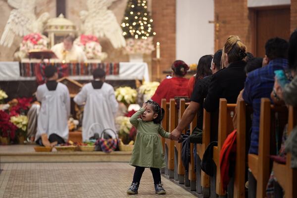 A child attends Mass at St. Mary's Catholic Church to celebrate the feast day of Guatemala's Black Christ of Esquipulas in Worthington, Minnesota, Sunday, Jan. 12, 2025. (AP Photo/Abbie Parr)