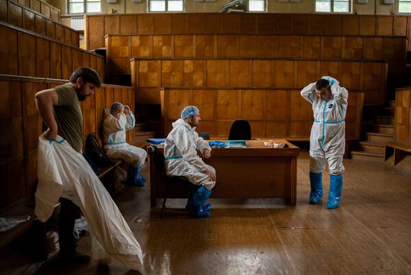 Workers change clothes at a morgue in Kyiv, Ukraine, June 24, 2024. (AP Photo/Alex Babenko)