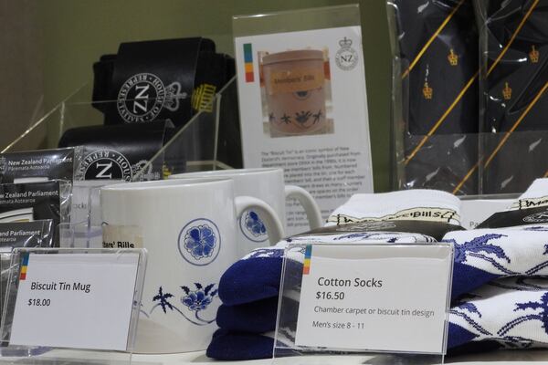 Socks are mugs printed with the biscuit tin pattern and label are seen for sale in the New Zealand Parliament gift shop in Wellington, New Zealand, Thursday, May 22, 2025. (AP Photo/Charlotte Graham-McLay)
