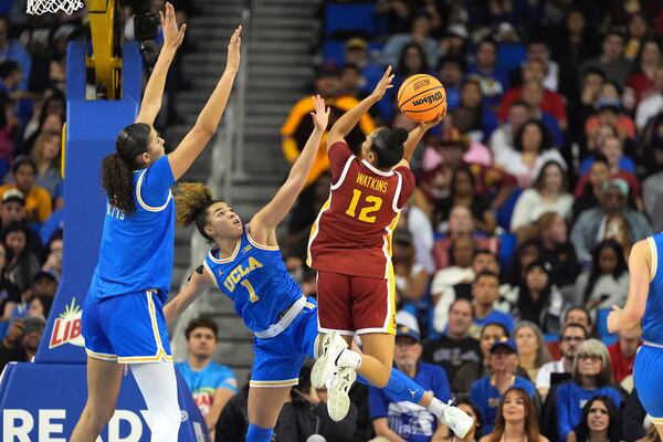 Southern California guard JuJu Watkins, right, shoots as UCLA center Lauren Betts, left, and guard Kiki Rice defend during the first half of an NCAA college basketball game Saturday, March 1, 2025, in Los Angeles. (AP Photo/Mark J. Terrill)