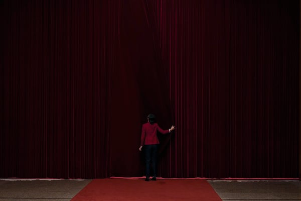 A hostess closes a curtain after delegates attending the opening session of the Chinese People's Political Consultative Conference at the Great Hall of the People in Beijing, Tuesday, March 4, 2025. (AP Photo/Andy Wong)