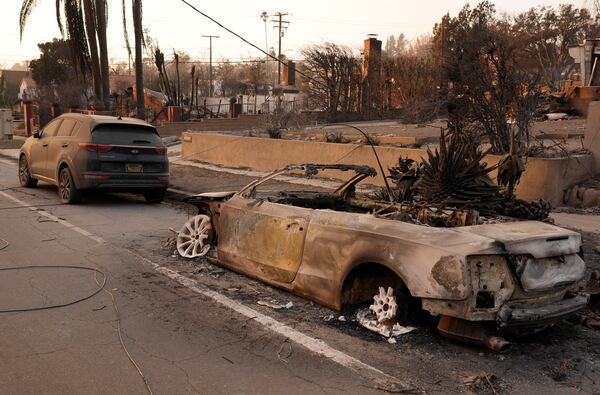 A car at right destroyed by the Eaton Fire sits next to an intact car, Thursday, Jan. 9, 2025, in Altadena, Calif. (AP Photo/Chris Pizzello)