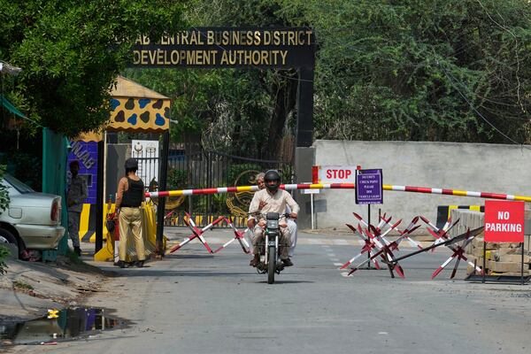 A motorcyclist drive through a checkpoint on an entry point to a garrison area, where a suspected Indian drone crashed, in Lahore, Pakistan, Thursday, May 8, 2025. (AP Photo/K.M. Chaudary)