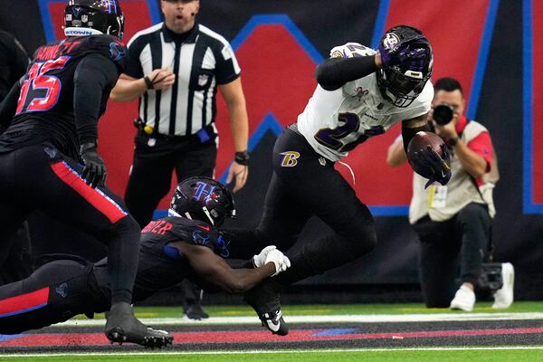 Baltimore Ravens running back Derrick Henry, right, is tackled by Houston Texans cornerback Kamari Lassiter for a safety during the first half of an NFL football game, Wednesday, Dec. 25, 2024, in Houston. (AP Photo/David J. Phillip)