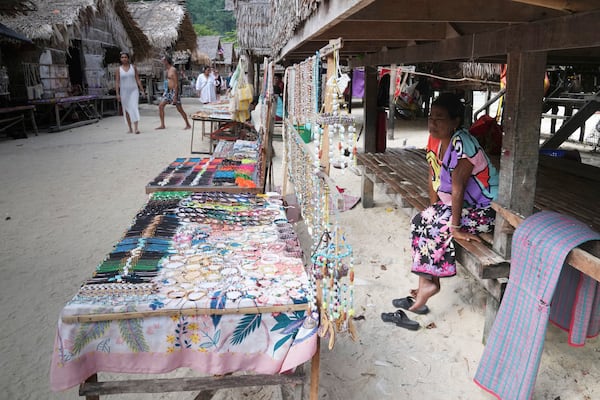 Bon Klathale wait for customers to sell souvenirs at Moken village at Surin Islands in Phang Nga Province, Thailand, Wednesday, Dec. 11, 2024. (AP Photo/Sakchai Lalit)